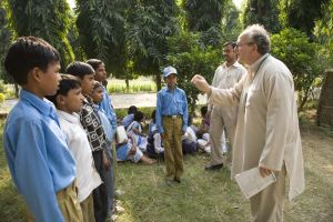 volunteer teaching a song to schoolchildren